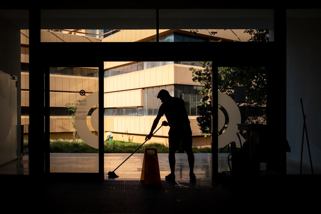 services-01 Man cleans floor at an entrance door.